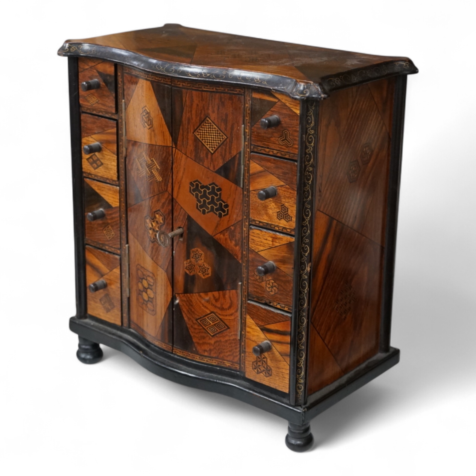 A Japanese parquetry table cabinet with eight drawers, the interior lacquered with figures, birds and spider, 30cm high